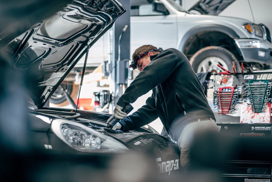 an image of a mechanic servicing a Porsche